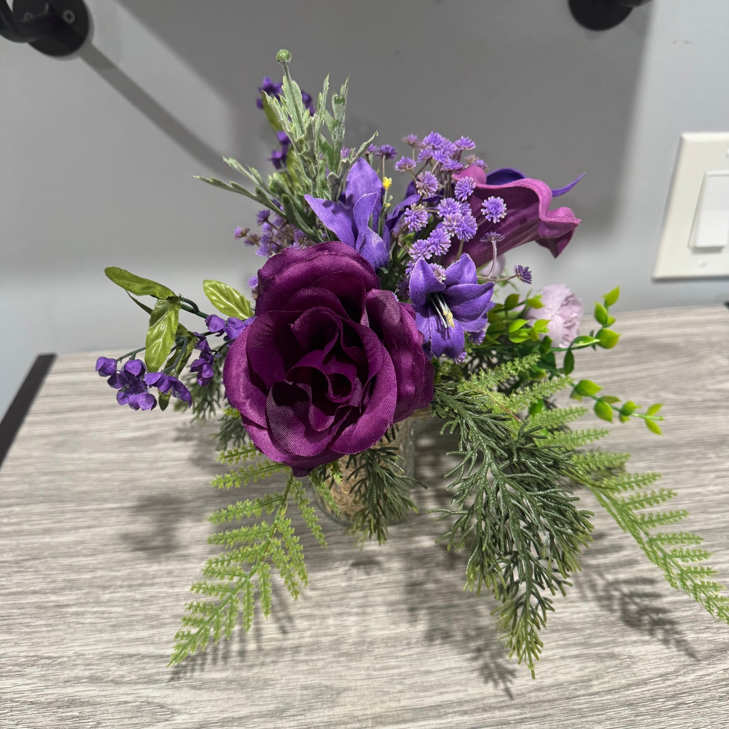 Glass jar with purple flowers