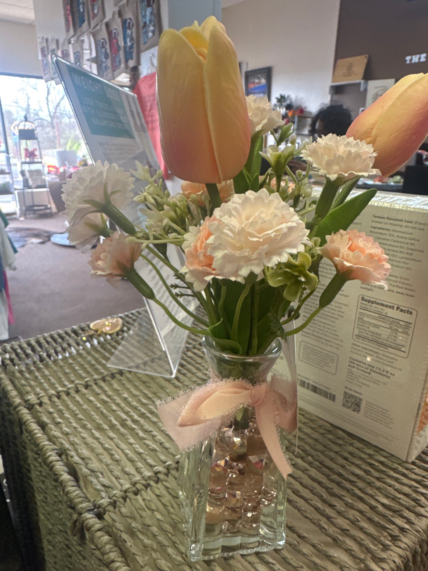 Glass vase with beads and pink flowers