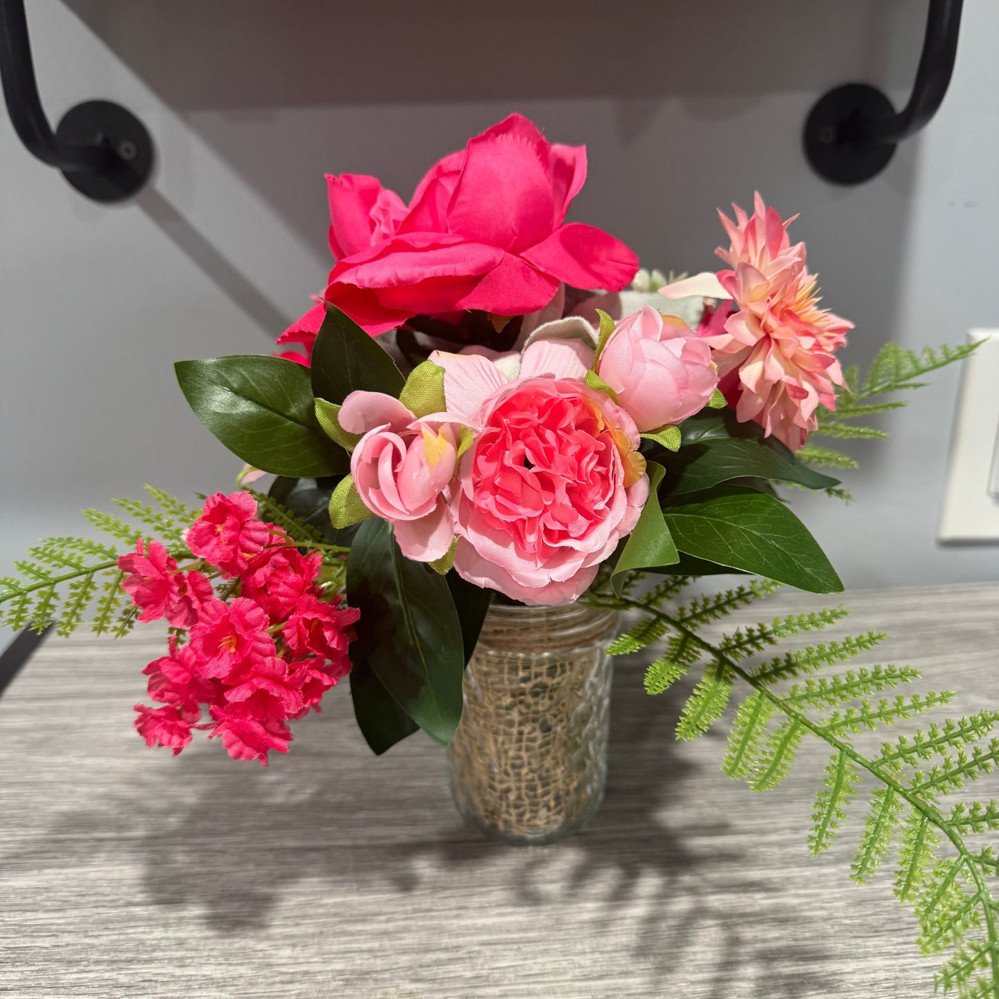Glass jar with pink flowers