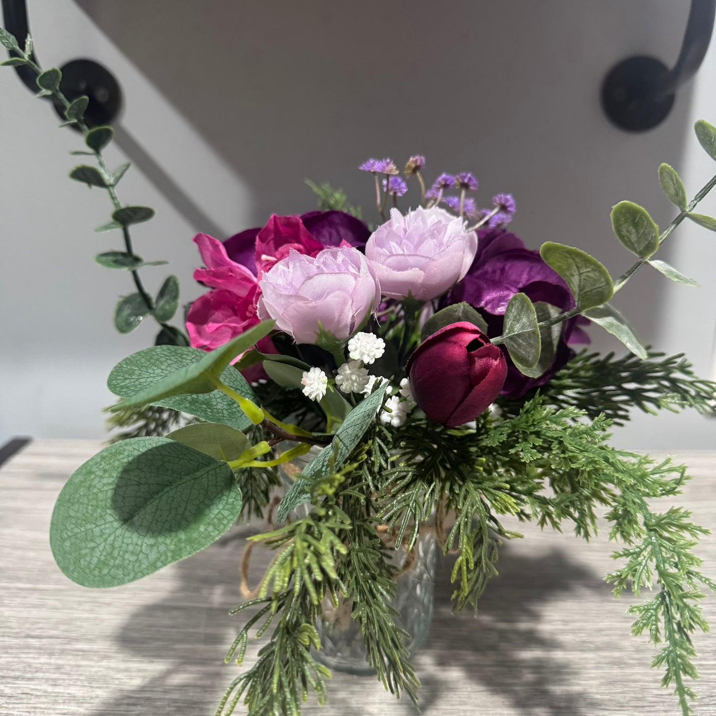 Glass jar with purple flowers
