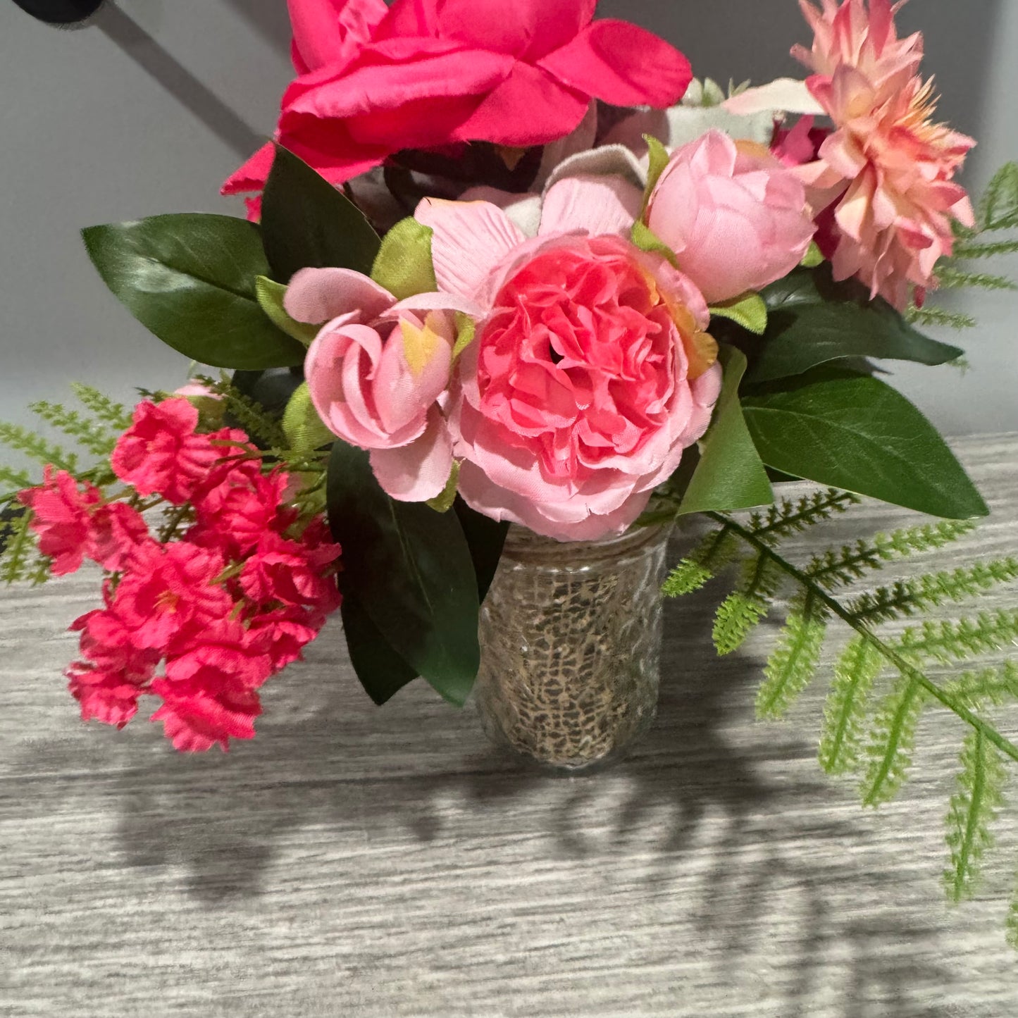 Glass jar with pink flowers